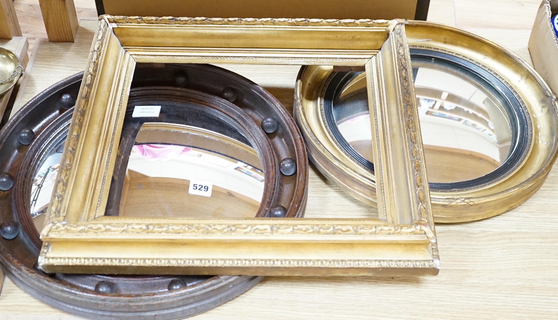 Two Victorian convex wall mirrors and a gilt painted picture frame, largest mirror 46cm diameter